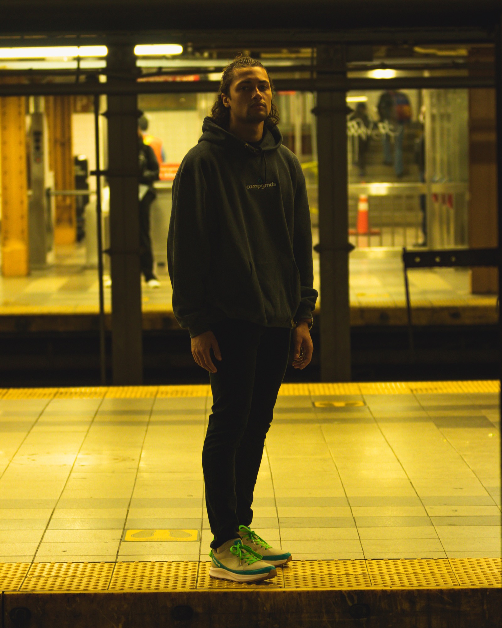 Brandon Webster on a subway platform in a Campgrnds hoodie