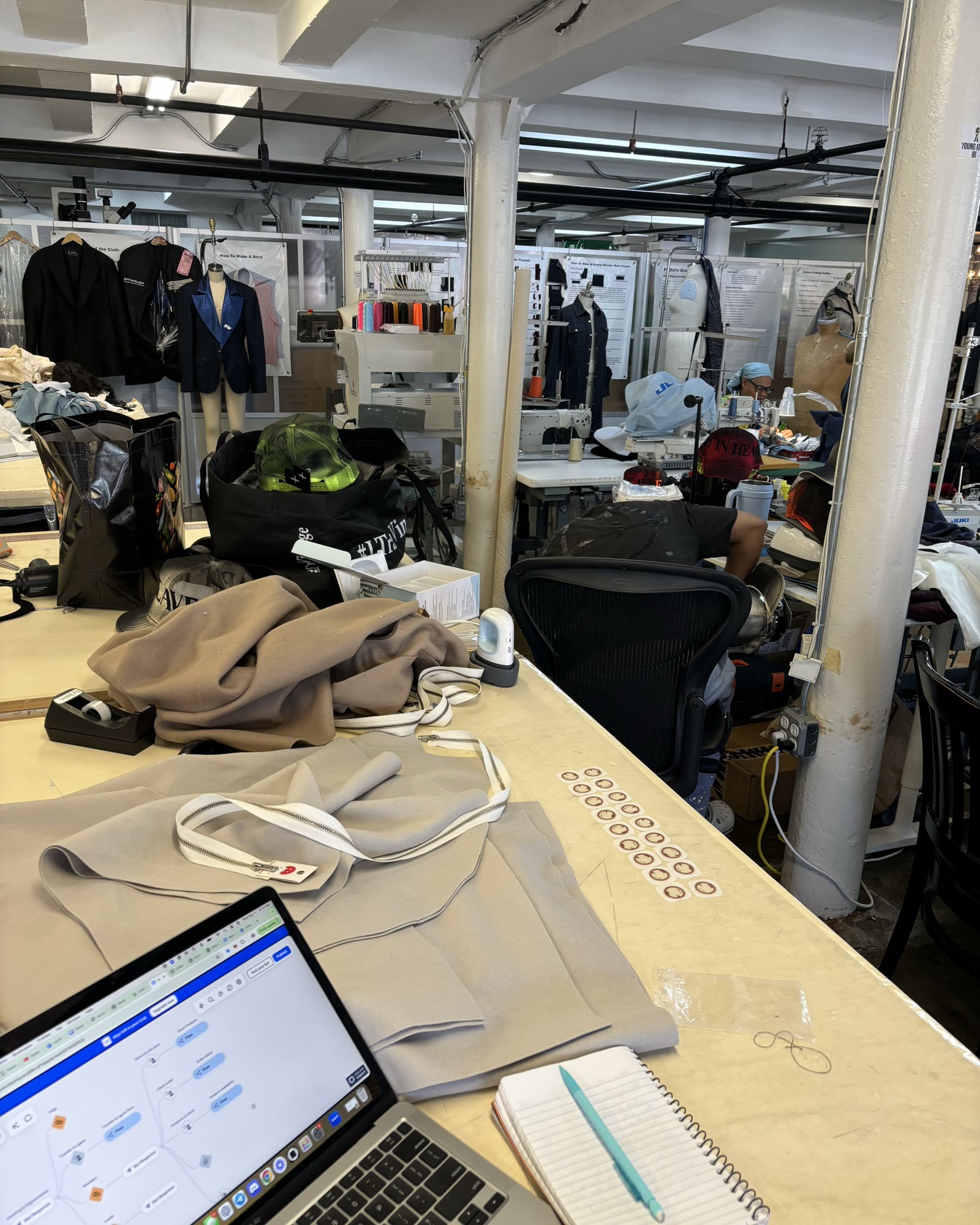 Studio workbench with a laptop and folded garments
