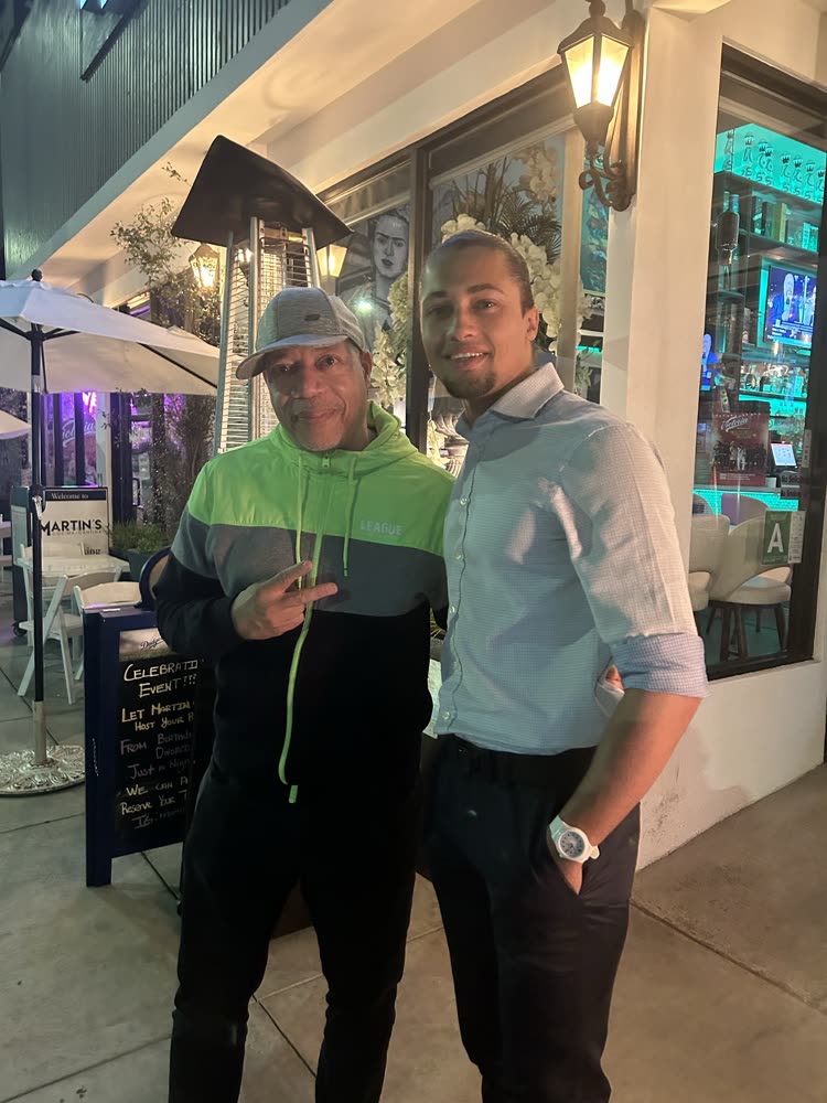 Brandon Webster with a guest outside a storefront